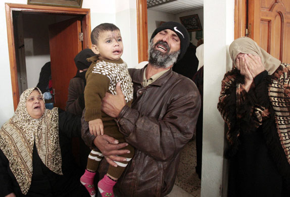 Anwar Balousha, bapa kepada 5 beradik yang terbunuh, meratap sambil mendukung anaknya yang tercedera