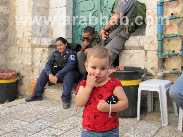 Anak kecil ini di hadapan rumahnya yang dipaksa keluar oleh tentera Zionis yang tersenyum memerhati