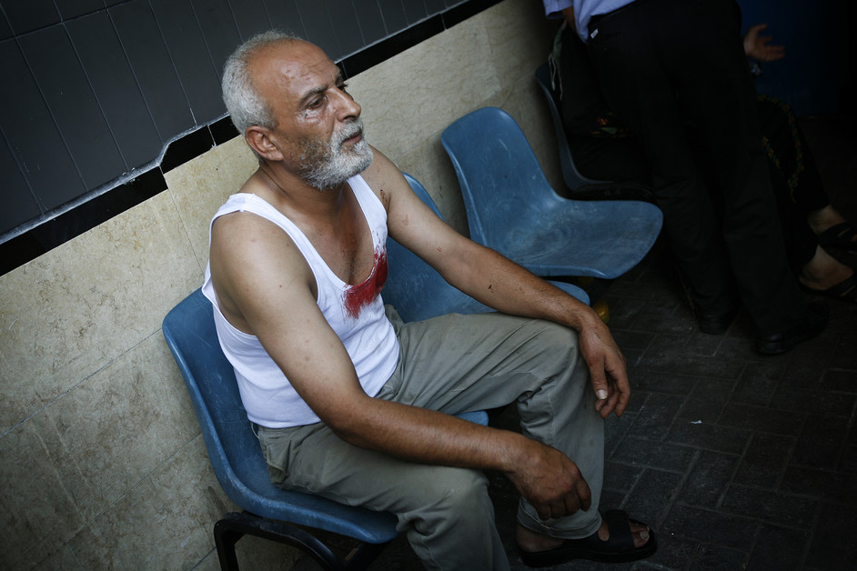 28 Julai - Lelaki ini duduk dalam keadaan terkejut di luar Hospital Al-Shifa di Gaza City. Beliau membantu membawa dua kanak-kanak yang terbunuh dalam serangan peluru berpandu berdekatan sebuah taman di kem pelarian pantai Gaza. Seorang lelaki serta sembilan kanak-kanak dilaporkan terkorban dalam serangan tersebut.