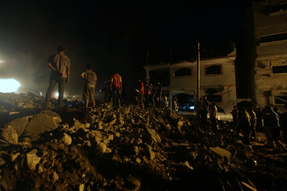 Penduduk cuba mencari mangsa di kawasan runtuhan rumah Al-Batsh yang ranap.