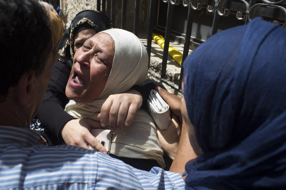 27 Julai - Ibu saudara Mohammad Abu Latifa bersedih semasa upacara pengkebumian di kem pelarian Qalandiya di Ramallah. Keluarganya mendakwa remaja tersebut ditembak dan dibunuh oleh tentera Zionis, yang sebaliknya mendakwa Mohammad meninggal dunia akibat terjatuh dari bumbung.